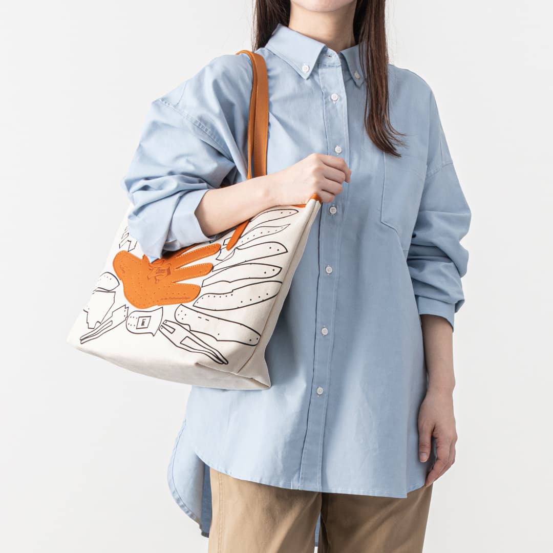 女性がキャンバストートバッグを持っている様子