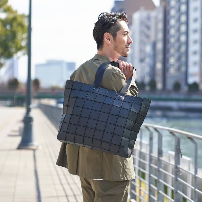 大容量で軽いレザートートバッグをメンズが着用