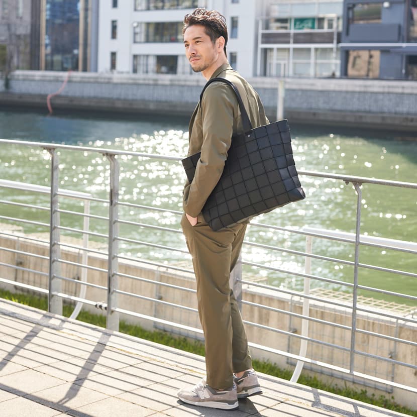 大容量で軽いレザートートバッグをメンズが着用