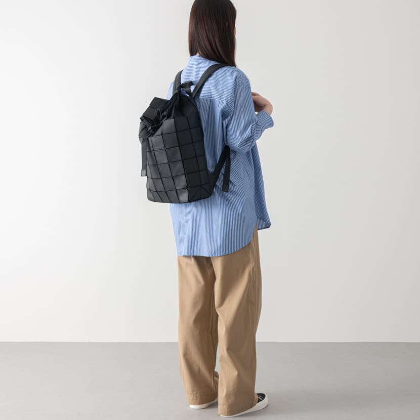軽いブラックのレザーリュックをレディスが持っている
