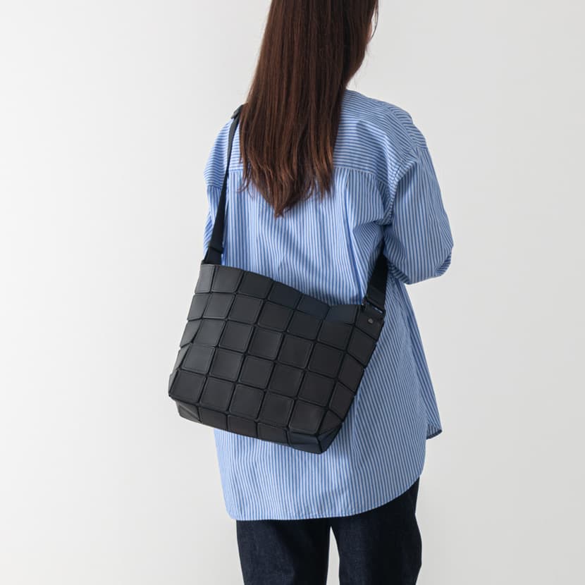 軽い黒のレザーショルダーバッグをレディスが持っている