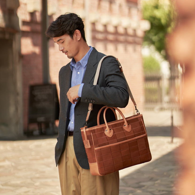 TRIONのレザートートバッグ横型を男性が着用
